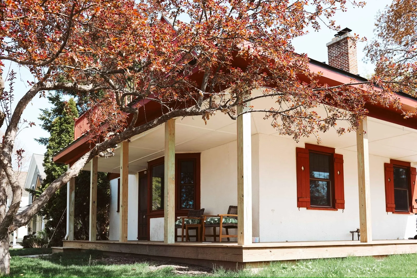 White siding, red shutters, wrapped porch posts