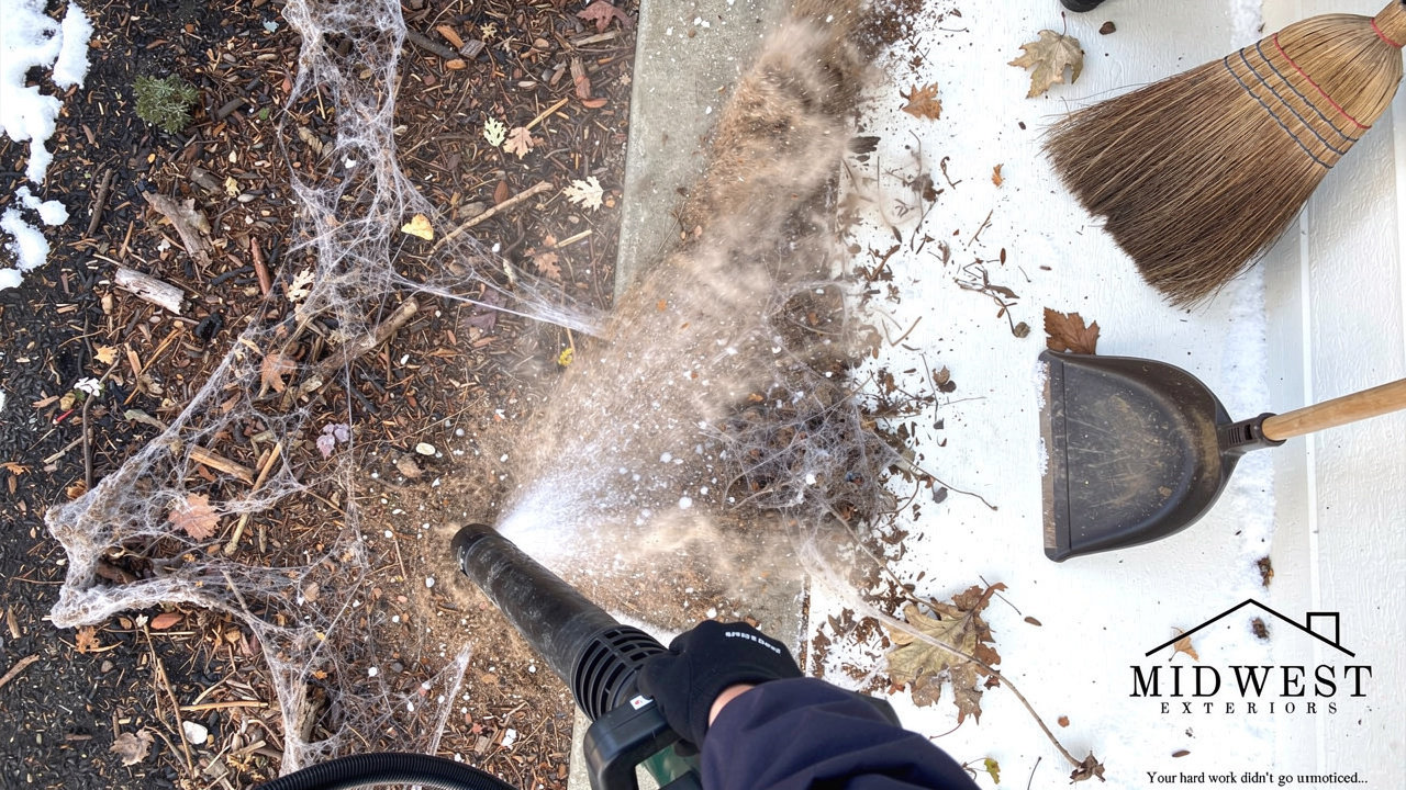 Leaf blower clearing winter debris and dust from a dirty porch surface
